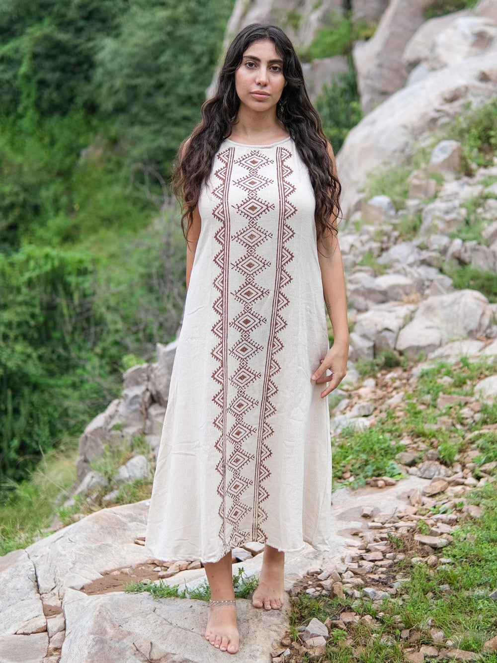 Ekakshi Maxi Dress in natural cotton with a brown block print front panel, worn sleeveless on a rocky trail