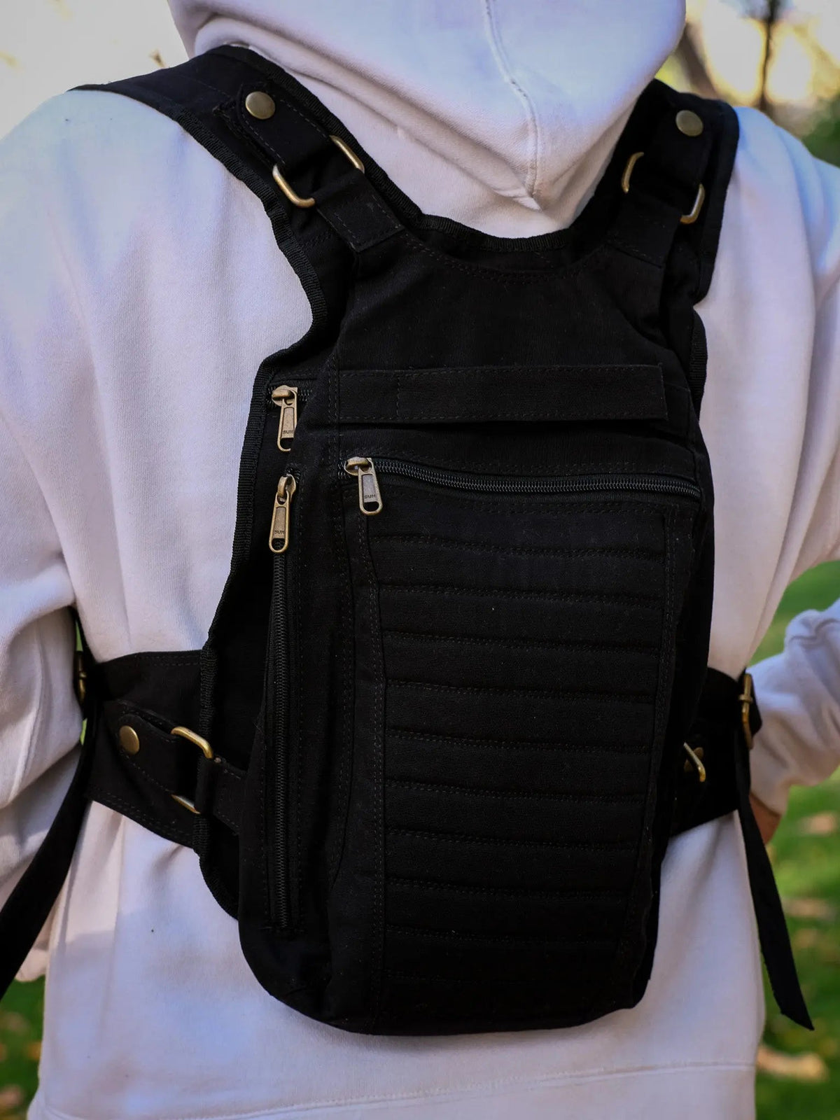 Black canvas Enigma Ninja Bag worn on the chest, buckled waist belt and side zip in view over a hoodie