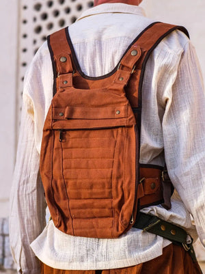 Rust brown cotton canvas Enigma Ninja Bag worn on the back at three-quarter angle, quilted panel facing out