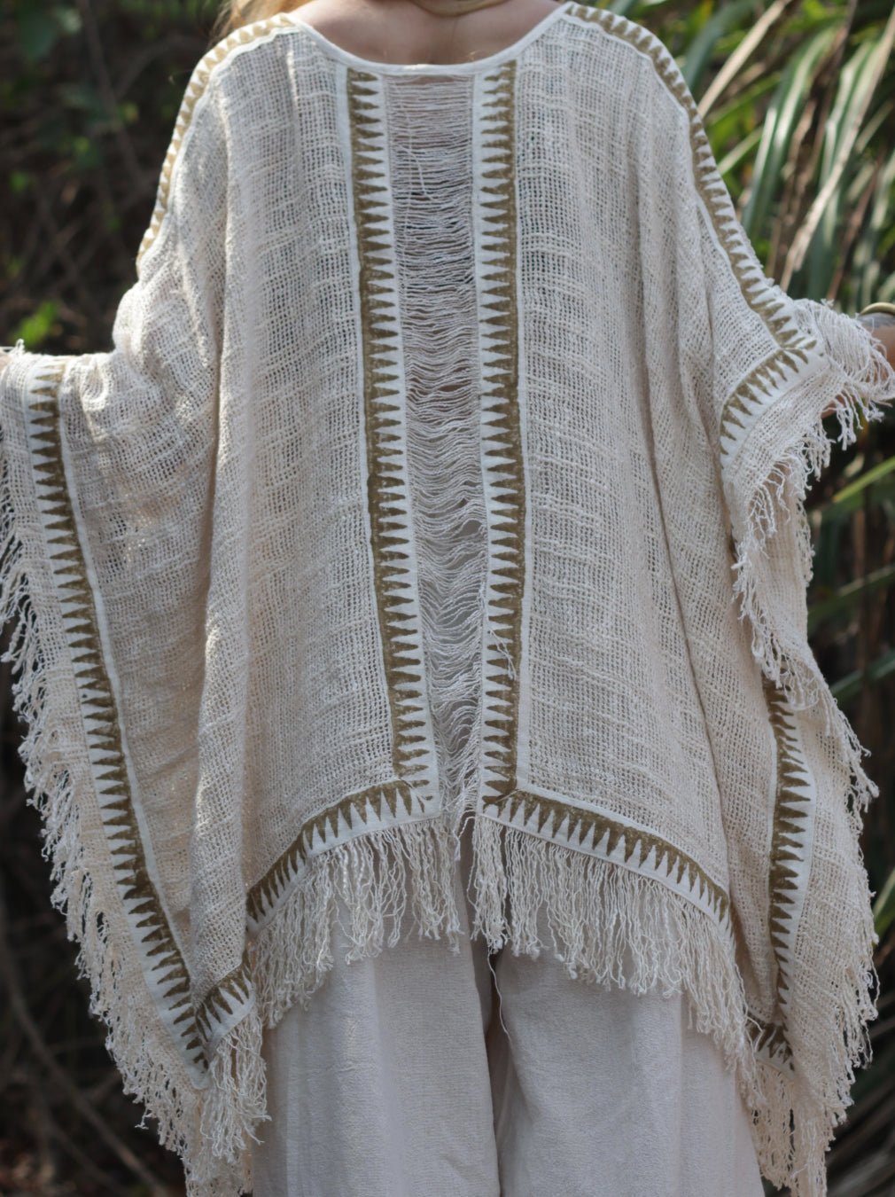 Esha Kaftan in natural cream, close back view of the ladder-stitch knit and fringe hem