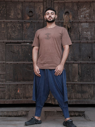 Full-length view of a brown cotton graphic t-shirt worn loose with a navy dhoti by a model in boho styling