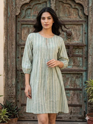 Gulbaan Dress in sage green and ivory stripes worn by a model at a Rajasthani carved wooden door, front view