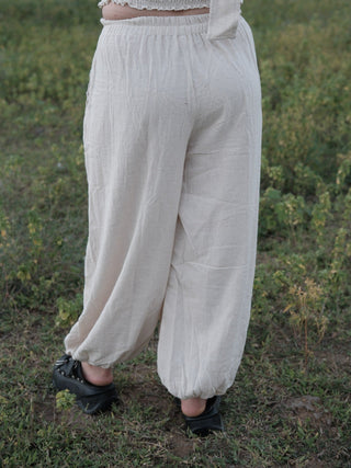Back view of Hoor harem pants showing the gathered elastic waistband and soft folds across the wide legs