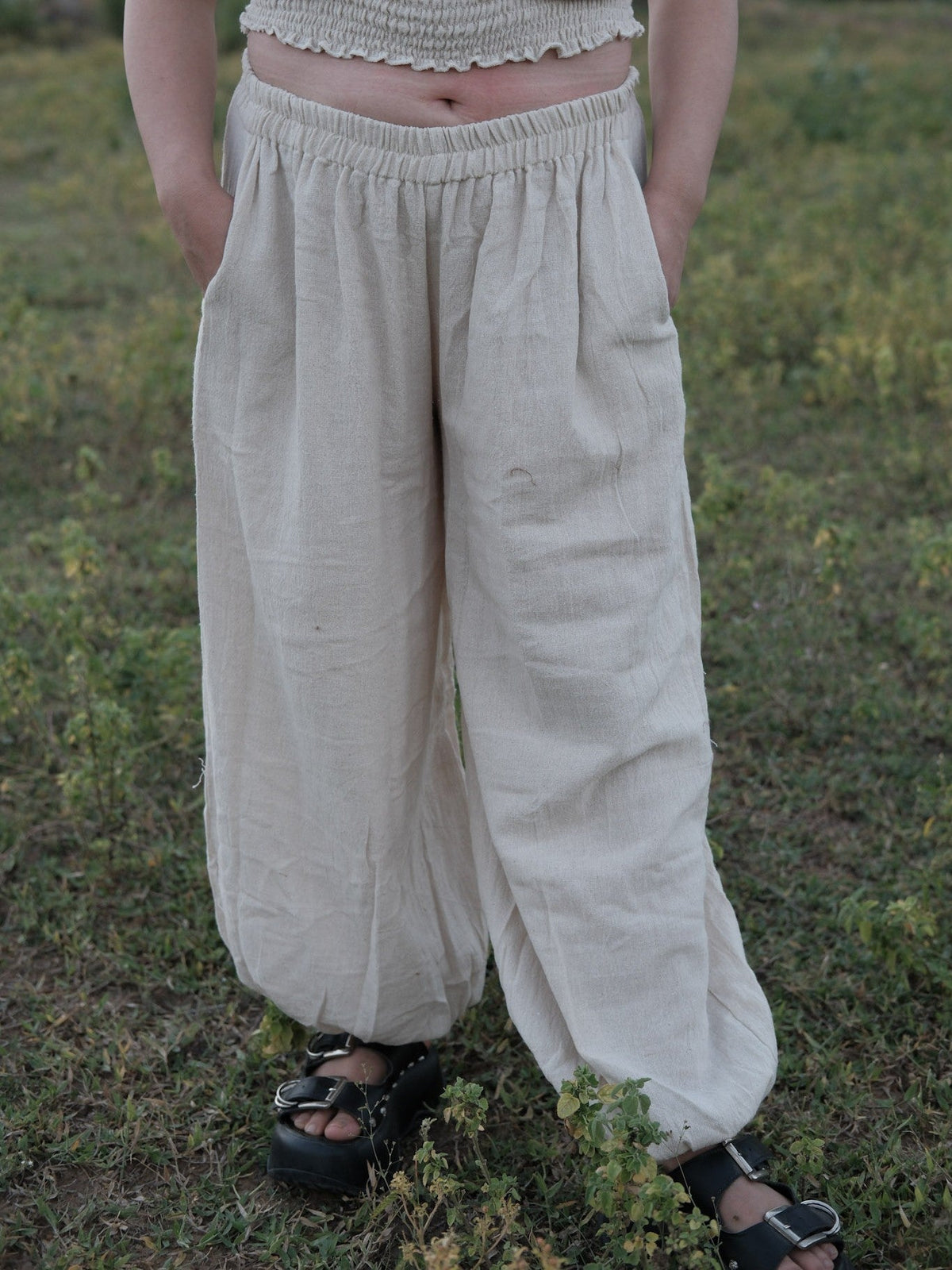 Hoor harem pants in natural ivory khadi cotton with hands in the side pockets and a gathered elastic waistband