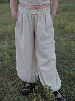 Hoor harem pants in natural ivory khadi cotton with hands in the side pockets and a gathered elastic waistband