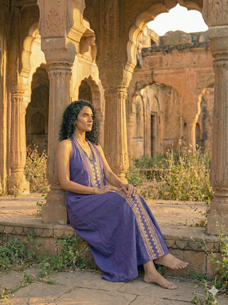 Idhika Dress in lavender purple, seated view of the cotton maxi in a carved haveli archway
