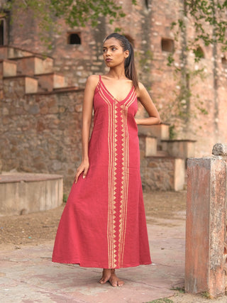 Idhika Dress in maroon, front view of the block print cotton maxi beside a haveli ledge