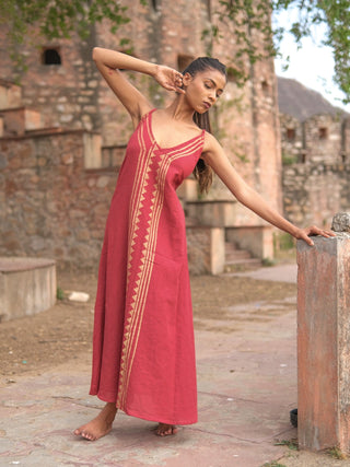 Idhika Dress in maroon, front view of the hand block print cotton maxi beside a haveli wall