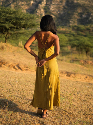 Idhika Dress in olive green, back view of the cotton maxi with crossed back straps in a haveli courtyard