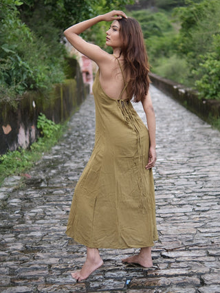 Idhika Dress in olive green, back view of the cotton maxi walking a stone path