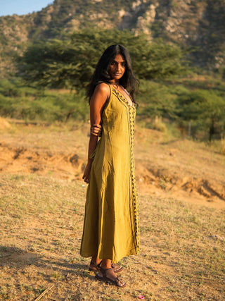 Idhika Dress in olive green, front view of the free-size cotton maxi on an open hillside