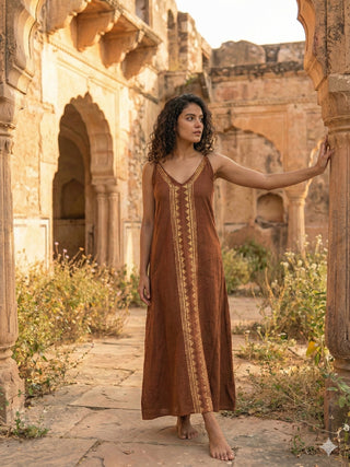 Idhika Dress in rust brown, front view of the block print cotton maxi at a carved ruin arch