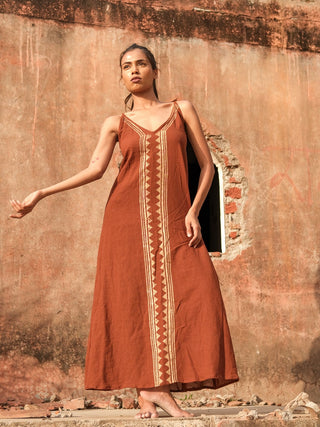 Idhika Dress in rust brown, front view of the hand block print cotton maxi at a ruin archway