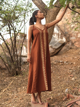 Idhika Dress in rust brown, front view of the cotton block print maxi beneath a tree branch