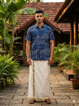 Full-length view of an indigo block print cotton shirt for men worn with a cream dhoti in a courtyard
