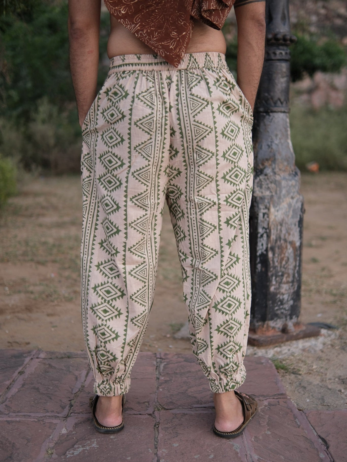 Back view of the Kathan unisex harem pants in beige cotton with all over olive green tribal print