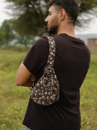 Khaak grey skull-print cotton festival bag worn crossbody over the shoulder, model facing away