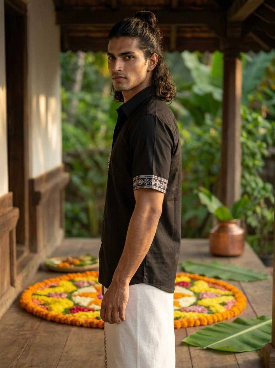 Close-up of the black Koothu Kathakali shirt fabric, showing the cotton slub texture with white screen-printed artwork.