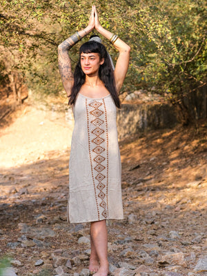 Model wearing the Lina Dress with arms raised, showing the free size A-line fall of the beige block print cotton dress