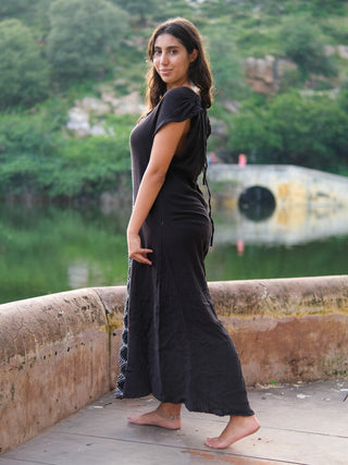 Side profile of the Narmada Maxi Dress in black crinkle cotton gauze worn outdoors