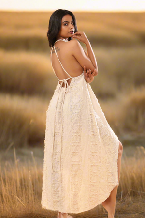 Cream high-low dress back view with waist tie at sunset