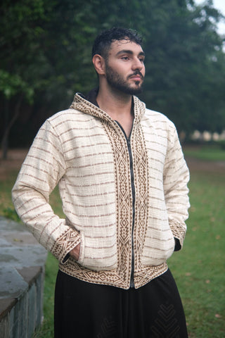 Nomad hoodie jacket from the front at an angle, head turned, both hands tucked into the hip pockets