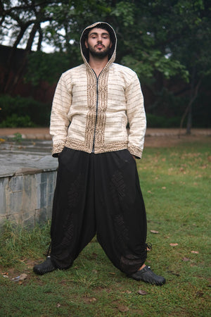 Full length view of the Nomad striped hoodie jacket with the hood up, wide black trousers