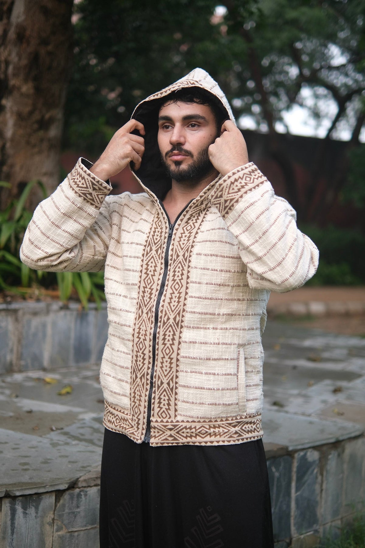 Model pulling the deep hood up on the Nomad cotton zip jacket, print placket bands either side of the zip