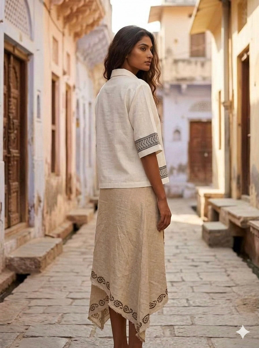 Three-quarter view of the ivory Noorrekha Shirt walking a sunlit lane, black chevron printed placket in view