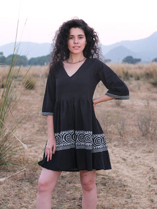 Black Nupura Short Dress, boho mini dress shown full length from the front with hands resting on the hips