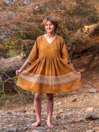 Camel brown Nupura Short Dress, boho mini dress shown full length from the front with the flared hem held out