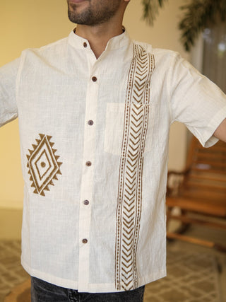 Close view of off-white arrow print shirt showing brown geometric panel, chest pocket and wooden-look buttons