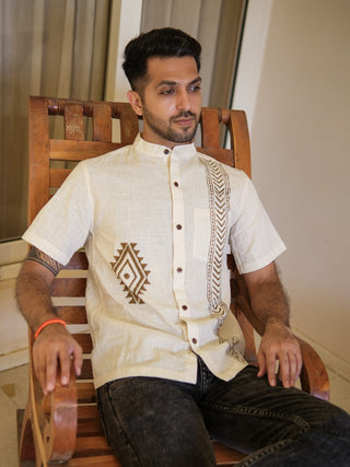 Seated model wearing off-white boho arrow print shirt with short sleeves and mandarin collar