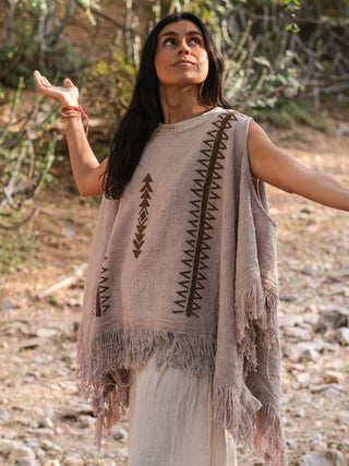 Grey-beige Parvati cotton kimono with fringe trim, model with arms raised in warm sunlight