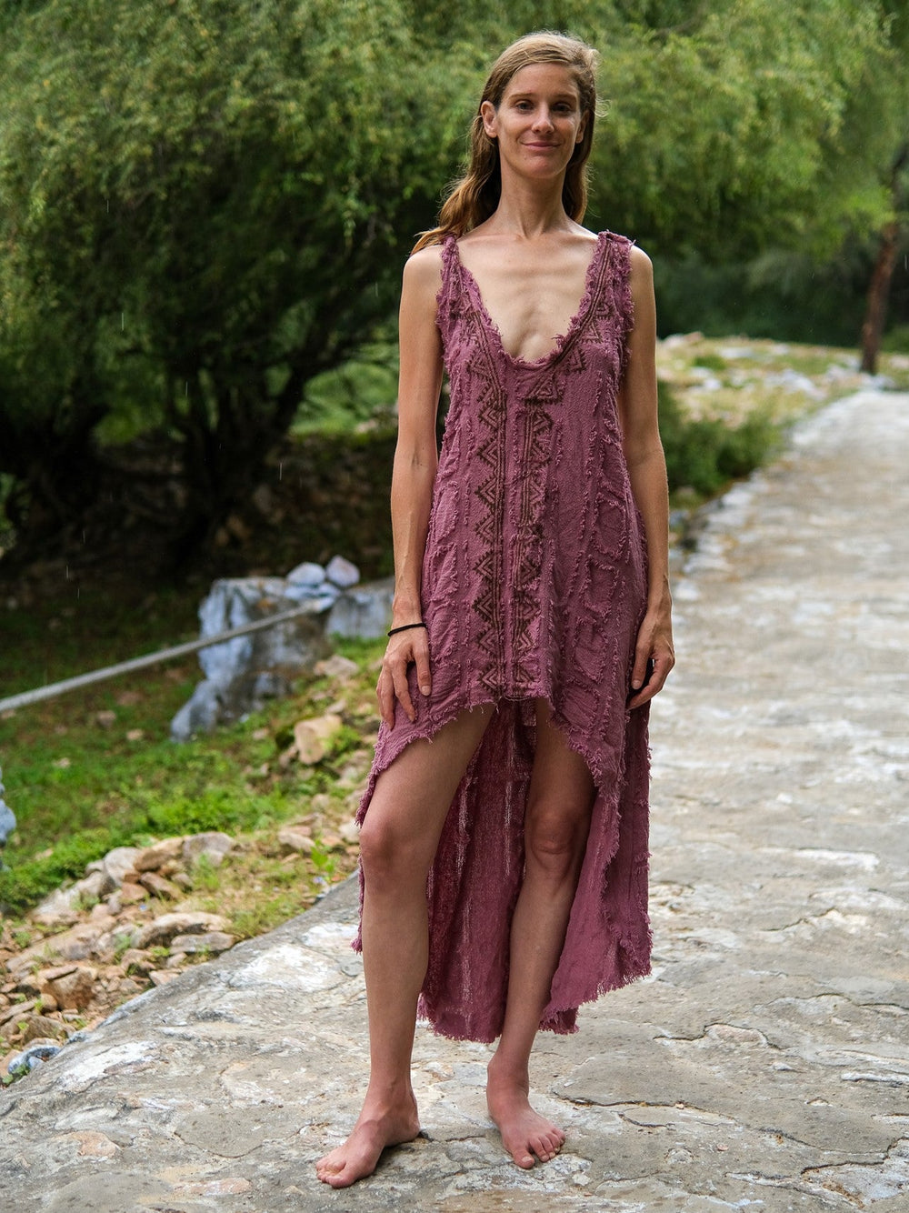 Pink crinkle cotton high-low dress with V-neck, front view on garden path