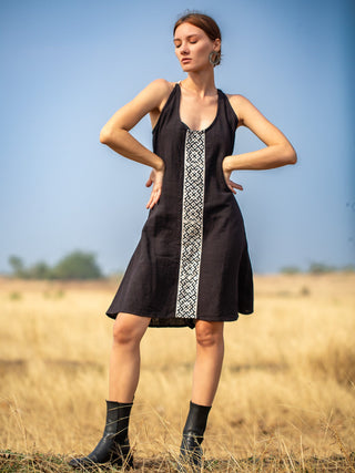 Rope Dress in black cotton-jute, model with hands on hips showing the front handblock print panel and sleeveless halter cut