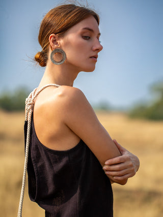 Close-up of the rope shoulder tie and open back on the black cotton-jute Rope Dress, model in profile