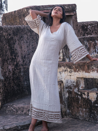 Samudra Maxi Dress natural cotton jute block print hem, model against fort wall, head tilted back