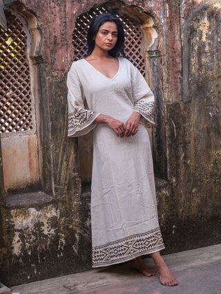 Samudra Maxi Dress natural cotton jute, model in a carved stone archway with hands clasped