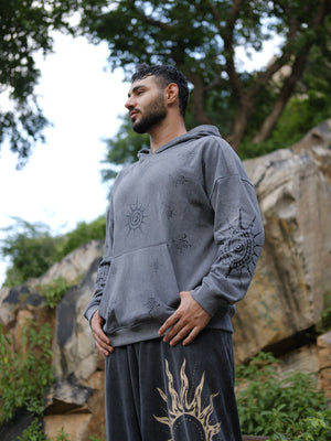 Side view of the grey Shaam Hoodie showing the kangaroo pocket and sun motif on the sleeve