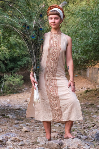 Close view of the Trishika hand block print maxi dress with the rust border, model holding peacock feathers