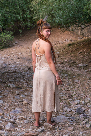 Back three quarter view of the Trishika halter maxi dress with braided hair, looking over the shoulder