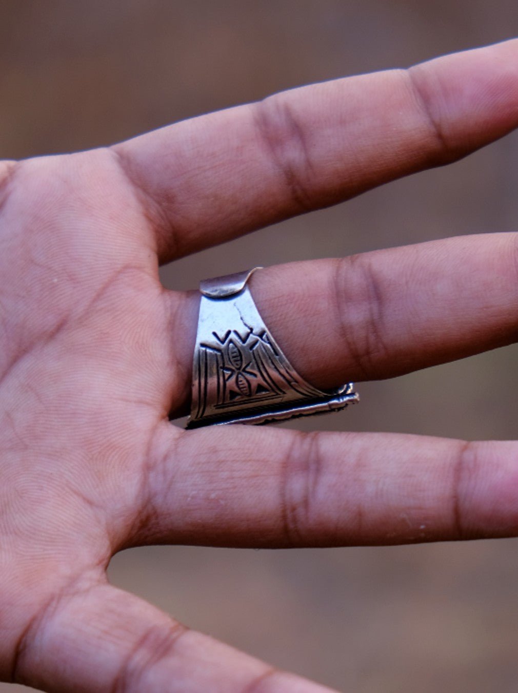 Palm-side view of the Tuareg ring worn on a finger, showing the tapered engraved underside and open adjustable band