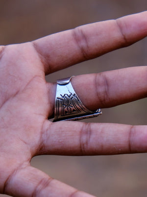 Palm-side view of the Tuareg ring worn on a finger, showing the tapered engraved underside and open adjustable band