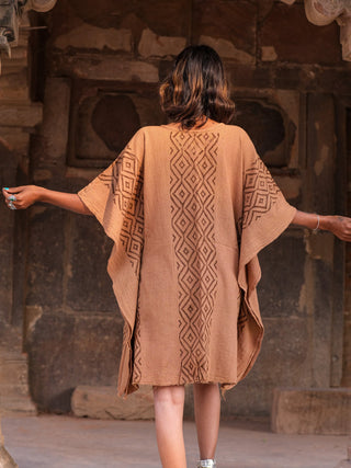Back view of terracotta Tula kaftan, hand block print cotton, model at temple ruins doorway