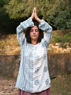 Woman in the white Om print kurta with blue medallions, boat neck and printed sleeve panels