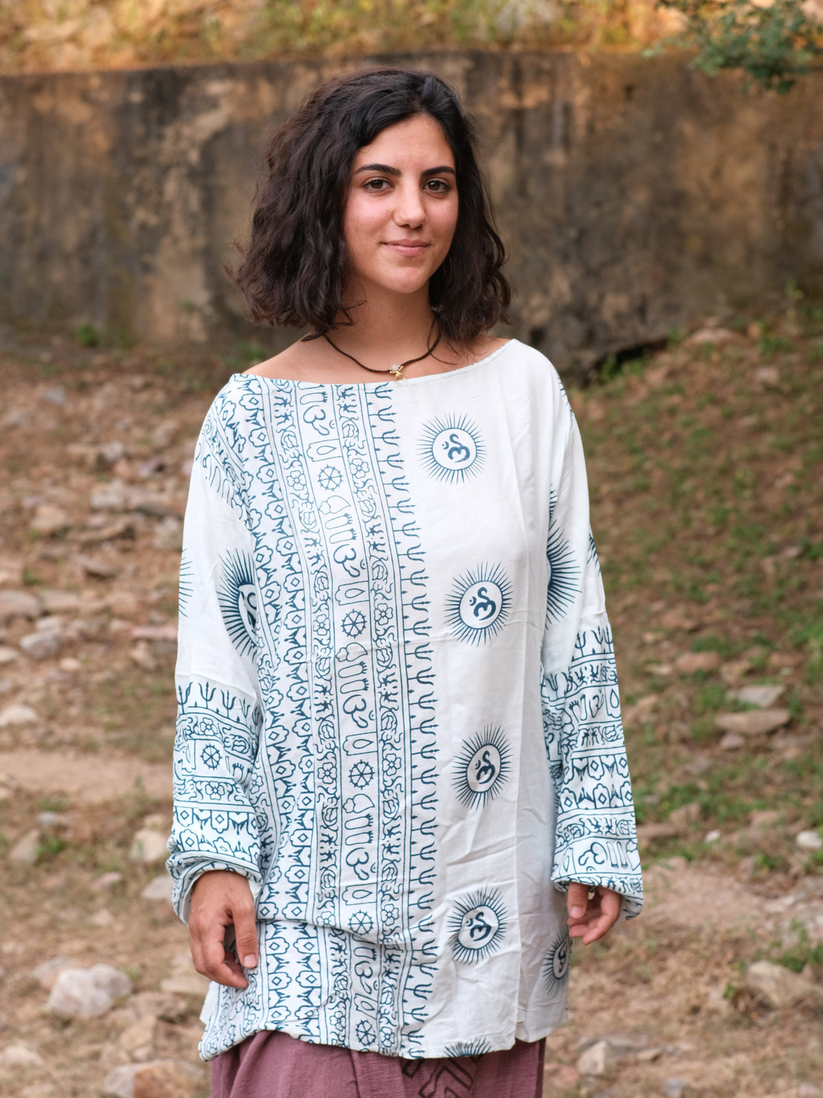 Woman in the white and blue Om print kurta, vertical Sanskrit script panels down the front