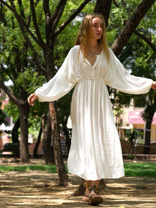 White flowy maxi dress with button front worn with arms outstretched