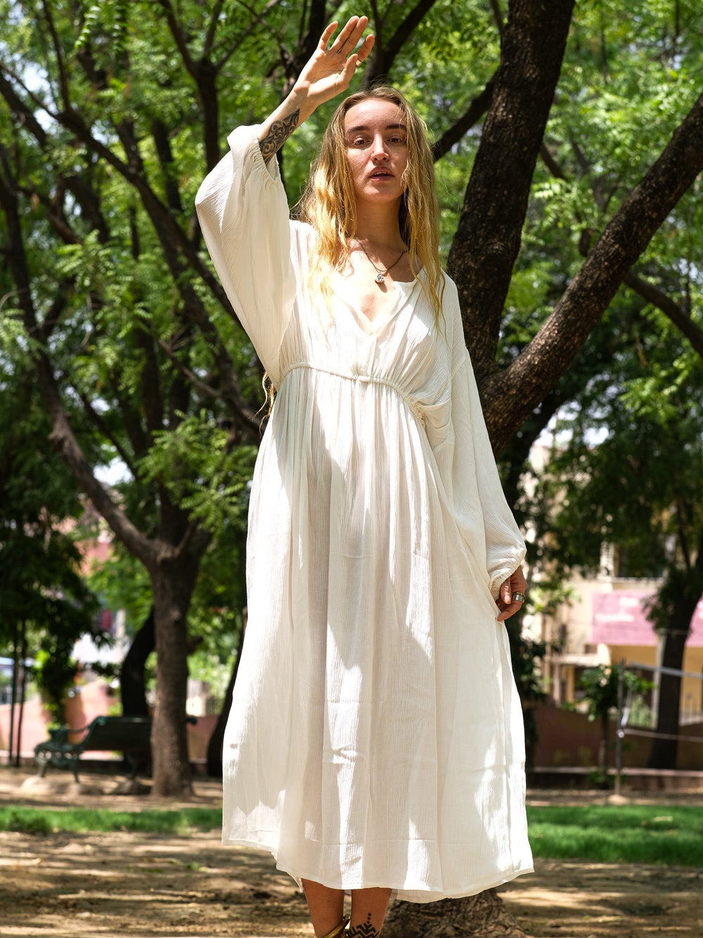 White rayon crepe boho maxi dress with balloon sleeves worn in a park